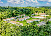 Thumbnail 5 of 25 - A bird's eye view of a residential area surrounded by green trees.