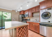 Thumbnail 3 of 21 - Kitchen, Wine Rack, Laundry Machine and Dishwasher at Whispering Brook Apartments, Des Moines, WA