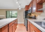 Thumbnail 4 of 21 - Kitchen Facing Outdoor Patio at Whispering Brook Apartments, Des Moines, WA,98198