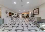 Thumbnail 2 of 13 - A long hallway with a checkered floor and a sign that says "Hamptons".
