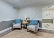 Thumbnail 9 of 13 - A room with two chairs and a table.