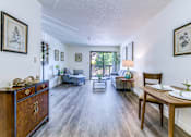 Thumbnail 4 of 13 - A living room with a grey couch and a wooden cabinet.