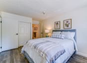 Thumbnail 6 of 13 - A bedroom with a large bed and a white door.
