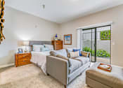 Thumbnail 17 of 28 - A bedroom with a bed, nightstand, and chair.
