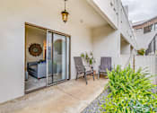 Thumbnail 8 of 28 - A patio with a chair and a table is visible through a glass door.