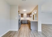 Thumbnail 16 of 28 - A kitchen with a refrigerator, cabinets, and a countertop.