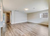 Thumbnail 5 of 28 - A room with wooden flooring and white walls.