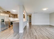 Thumbnail 2 of 28 - A spacious kitchen with stainless steel appliances and wooden flooring.