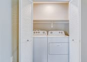 Thumbnail 25 of 28 - A small laundry room with a washer and dryer.