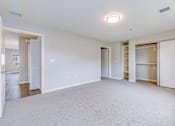 Thumbnail 9 of 28 - A spacious, empty room with white walls and carpeted floor.
