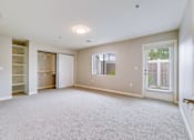 Thumbnail 12 of 28 - A spacious room with a carpeted floor and a window with blinds.