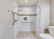 Thumbnail 15 of 28 - A white bathroom with a toilet, sink, and shower.