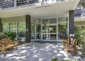 Thumbnail 14 of 23 - the front porch of a condo building with benches and glass doors