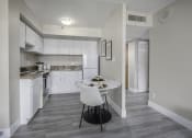Thumbnail 6 of 23 - a kitchen with white cabinets and white appliances and a white table