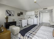 Thumbnail 9 of 23 - a bedroom with a bed and a kitchen with white cabinets