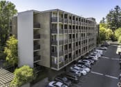 Thumbnail 23 of 23 - an office building with cars parked in a parking lot