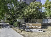 Thumbnail 21 of 23 - the riverview apartments sign in front of a sidewalk and trees