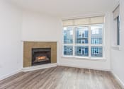 Thumbnail 8 of 28 - A room with a fireplace and a window showing a building outside.
