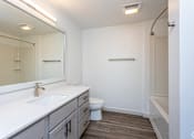 Thumbnail 14 of 28 - A white bathroom with a toilet, sink, and mirror.