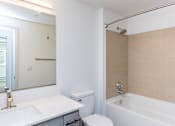 Thumbnail 21 of 28 - A white bathroom with a toilet, sink, and bathtub.