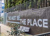 Thumbnail 2 of 28 - A wall with the words "This must be the place" painted on it.