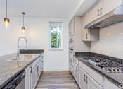 Thumbnail 6 of 28 - A kitchen with granite countertops and stainless steel appliances.
