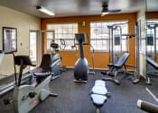 Thumbnail 31 of 34 - a gym with cardio equipment and weights with orange walls at 2000 Lake Washington Apartments, Washington