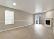 Thumbnail 7 of 34 - an empty living room with a fireplace and a sliding glass door at 2000 Lake Washington Apartments, Renton, WA