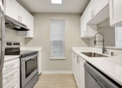 Thumbnail 2 of 34 - a kitchen with white cabinets and stainless steel appliances at 2000 Lake Washington Apartments, Renton