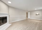 Thumbnail 4 of 34 - an empty living room with a fireplace and wood flooring at 2000 Lake Washington Apartments, Washington