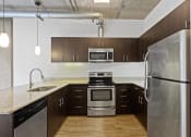 Thumbnail 25 of 46 - a kitchen with stainless steel appliances and a marble counter top at The Parker Apartments, Oregon, 97209