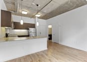 Thumbnail 26 of 46 - an open kitchen and living room with a kitchen counter top at The Parker Apartments, Oregon