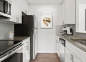 Thumbnail 1 of 31 - a modern kitchen with stainless steel appliances and marble counter tops