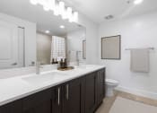 Thumbnail 23 of 56 - a bathroom with a sink and a toilet and a mirror at One Plantation in Plantation, FL 33324