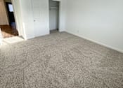 Thumbnail 18 of 34 - A room with a carpeted floor and a white door at 2000 Lake Washington Apartments, Renton, WA