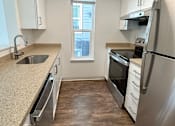 Thumbnail 12 of 34 - A kitchen with a stainless steel refrigerator, sink, and wooden flooring at 2000 Lake Washington Apartments, Renton, WA, 98056