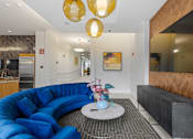 Thumbnail 29 of 42 - A blue sofa with a white coffee table in front of a mirror.