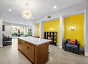 Thumbnail 14 of 42 - A white kitchen island with a wooden counter and a chandelier hanging from the ceiling.