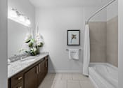Thumbnail 6 of 42 - A bathroom with a white tub, sink, and a framed picture on the wall.