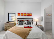Thumbnail 4 of 42 - A bedroom with a large bed and a dresser with a mirror.