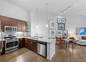Thumbnail 28 of 42 - A modern kitchen with wooden floors and stainless steel appliances.