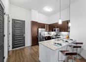 Thumbnail 1 of 42 - A kitchen with a white island and brown cabinets.