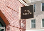 Thumbnail 32 of 39 - a bike lounge sign on the side of a brick building at The Merchant Apartments, South Carolina 29403