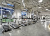Thumbnail 34 of 43 - a gym with cardio equipment and treadmills in a building at L Seven, San Francisco