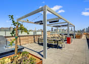 Thumbnail 26 of 43 - a rooftop patio with tables and chairs and a view of the city at L Seven, California