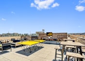 Thumbnail 24 of 43 - a rooftop patio with tables and chairs and a television at L Seven, California