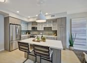 Thumbnail 14 of 43 - a kitchen with a large island and a stainless steel refrigerator at L Seven, California, 94103