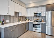 Thumbnail 9 of 43 - a kitchen with stainless steel appliances and white cabinets at L Seven, California, 94103