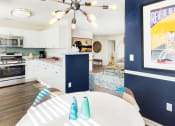 Thumbnail 12 of 28 - a kitchen and dining room with a table and a ceiling fan at Residences at Stevens Pond, Saugus, Massachusetts 01906