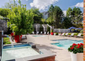 Thumbnail 5 of 28 - our apartments have a large pool and spa with chairs and plants at Residences at Stevens Pond, Massachusetts, 01906